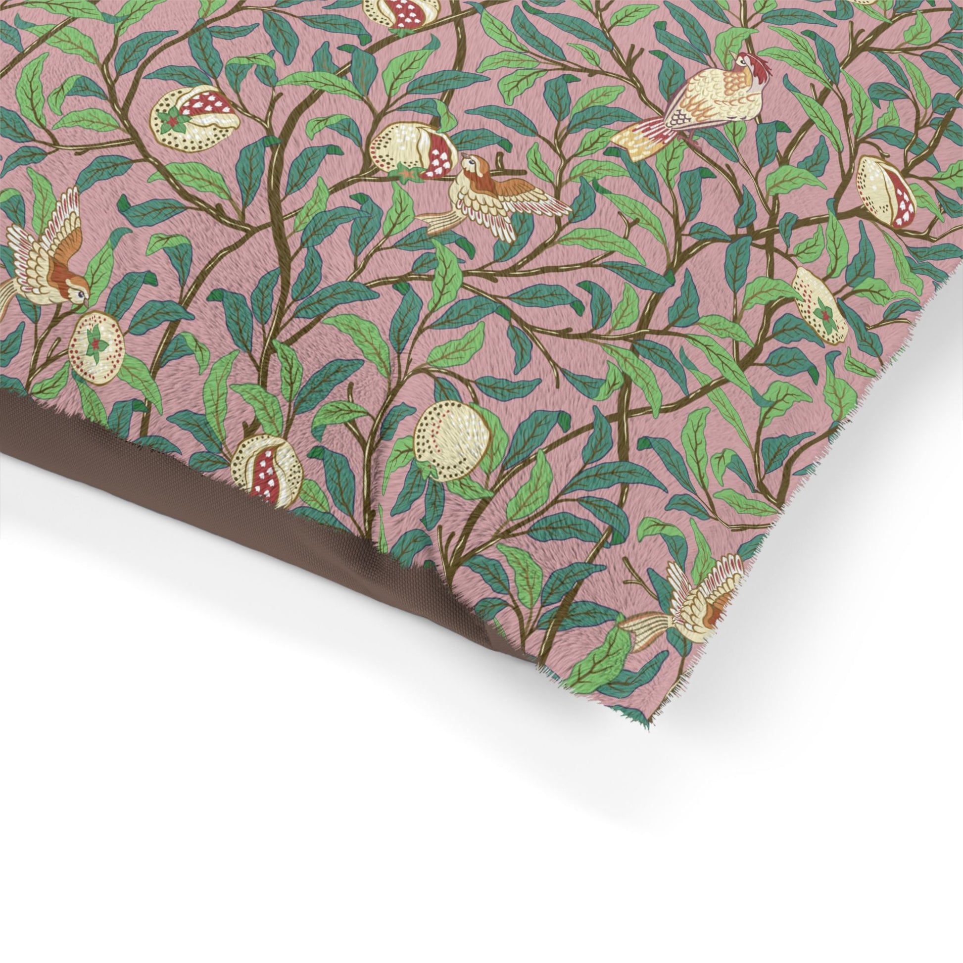 Fabric with a nature-themed pattern featuring birds, leaves, and flowers on a pink background.