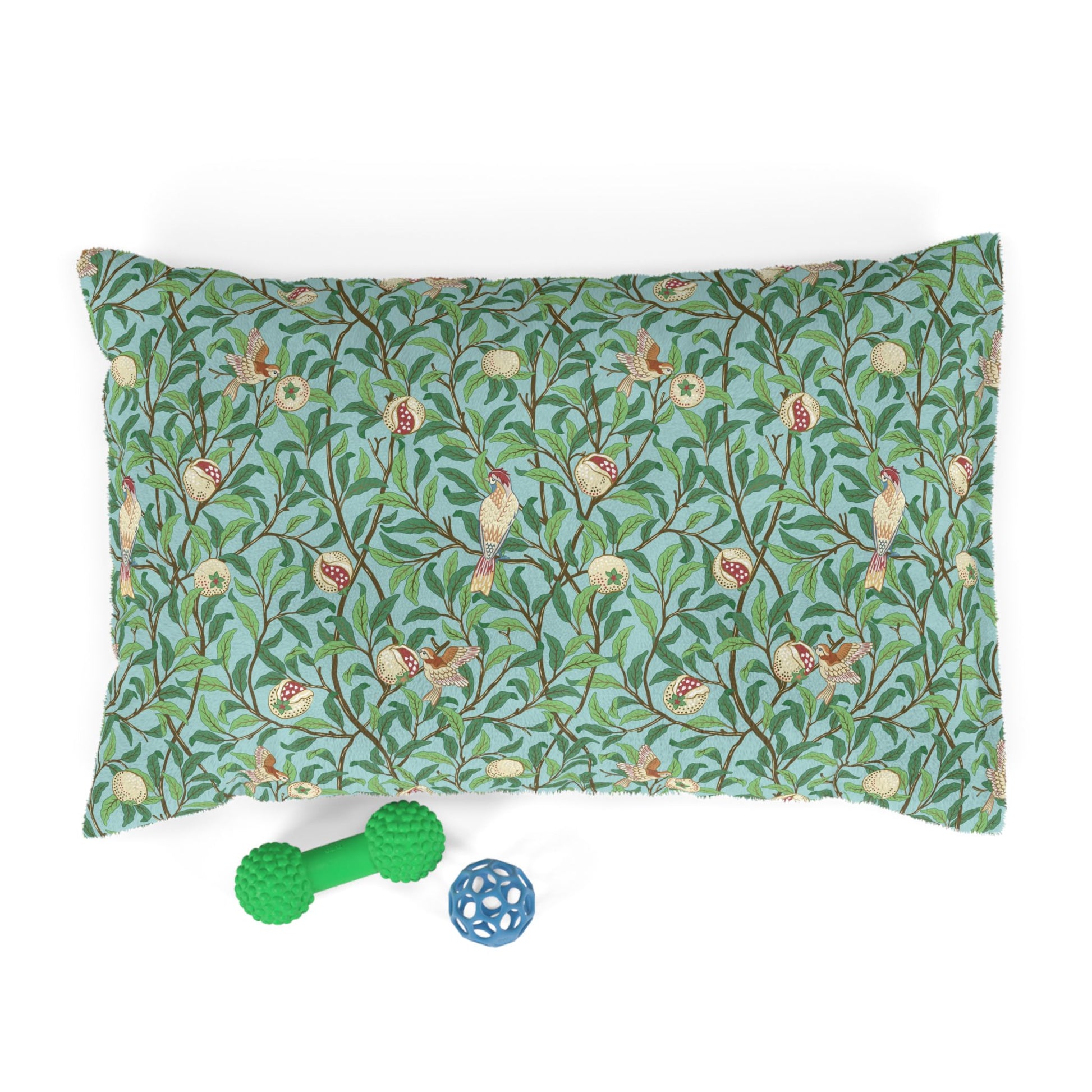 Decorative dog pillow with nature-themed William Morris & Co pattern and two pet toys on a white background