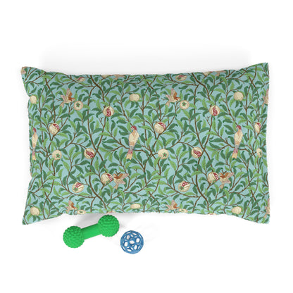 Decorative dog pillow with nature-themed William Morris & Co pattern and two pet toys on a white background