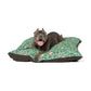 Dog lying on a William Morris & Co floral-patterned dog bed with a white background