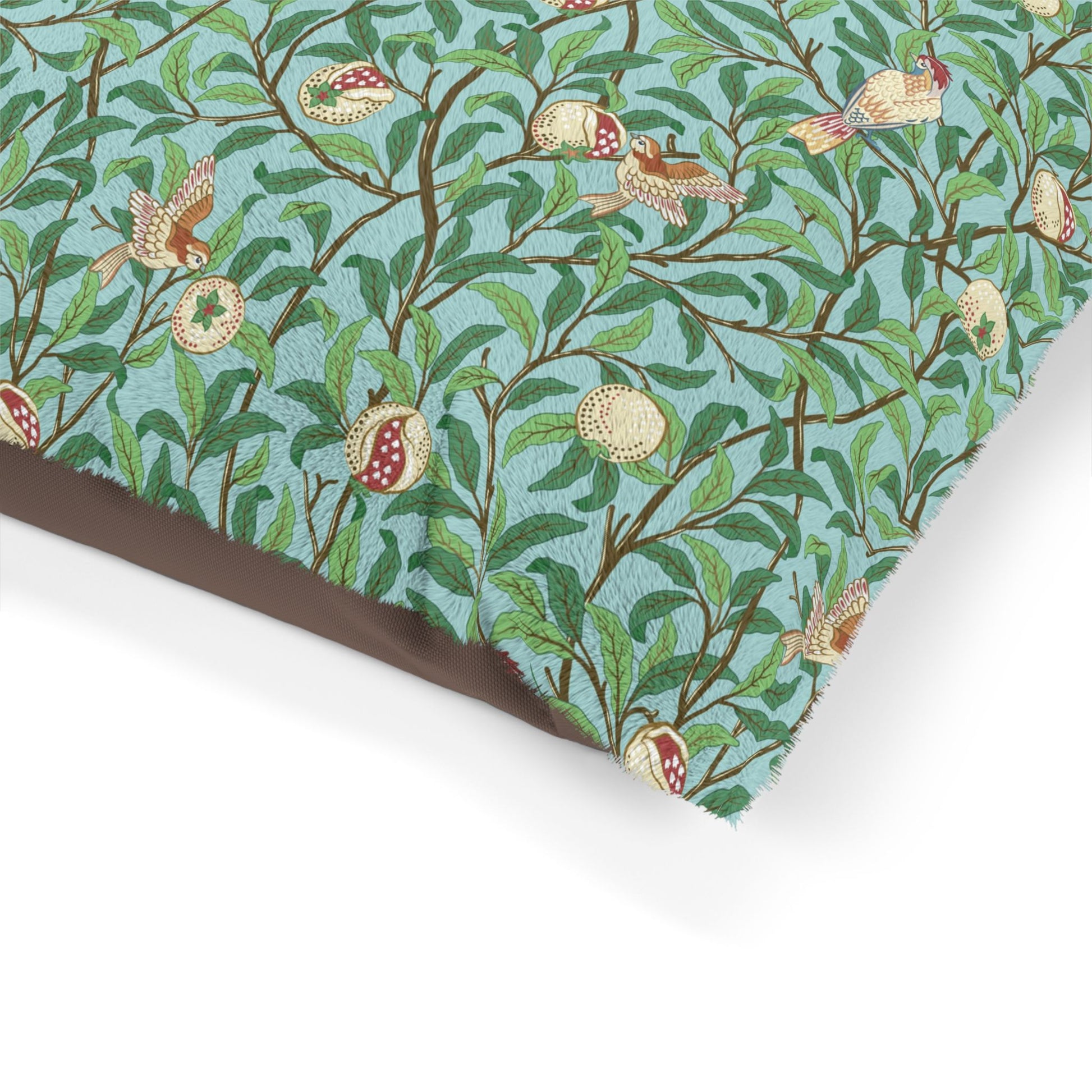 Fabric with a William Morris & Co pattern of birds and pomegranates on a blue background
