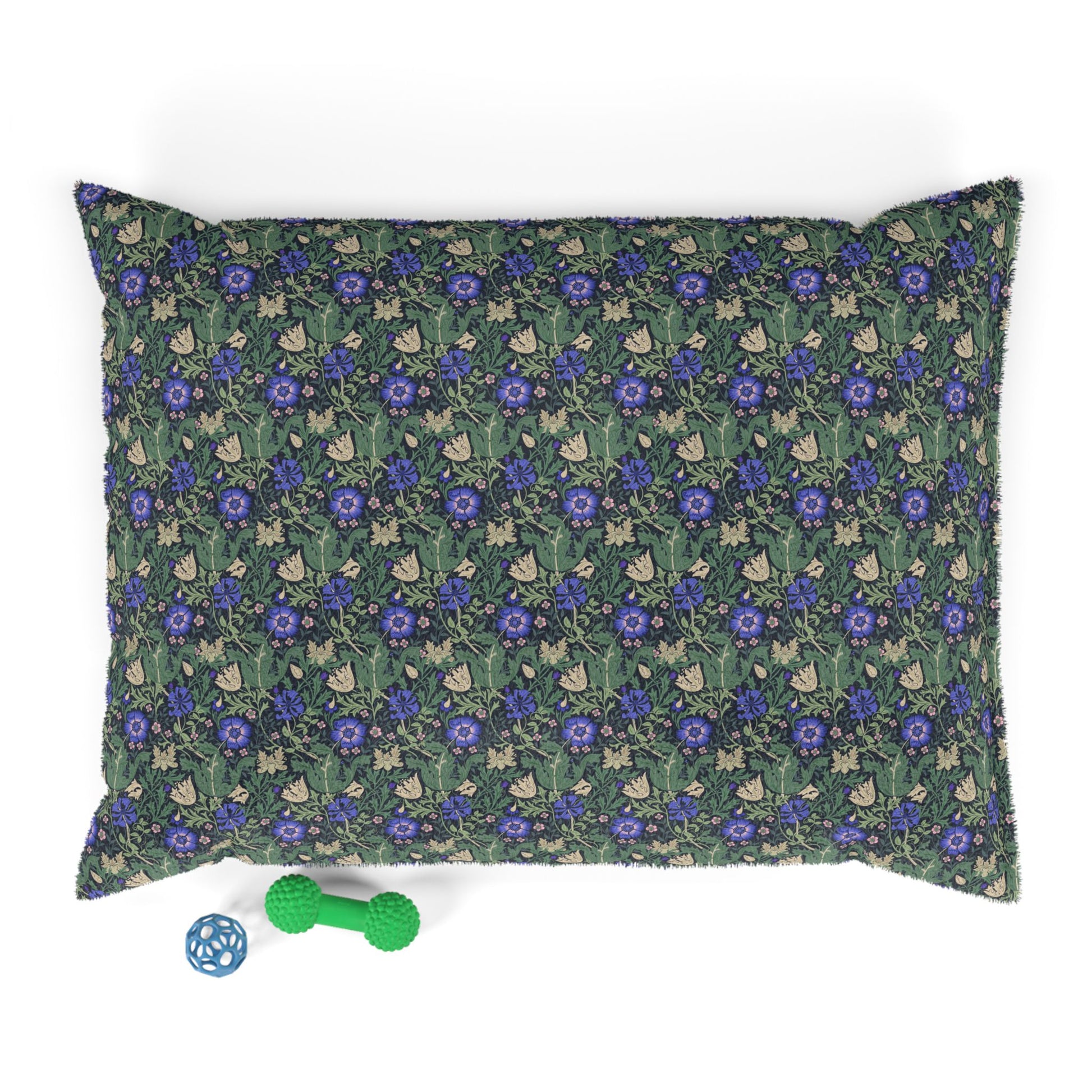 Floral-patterned pillow with a green dog toy on a white background