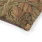 Close-up of a fabric with intricate William Morris & Co leaf pattern in brown and green on a white background