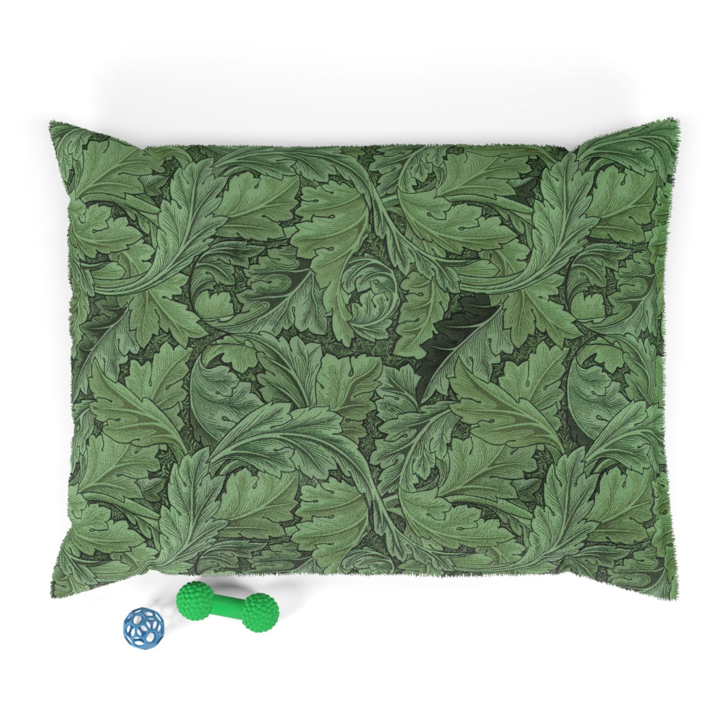 Green leaf-patterned pillow on a white background with two green dog toys below.