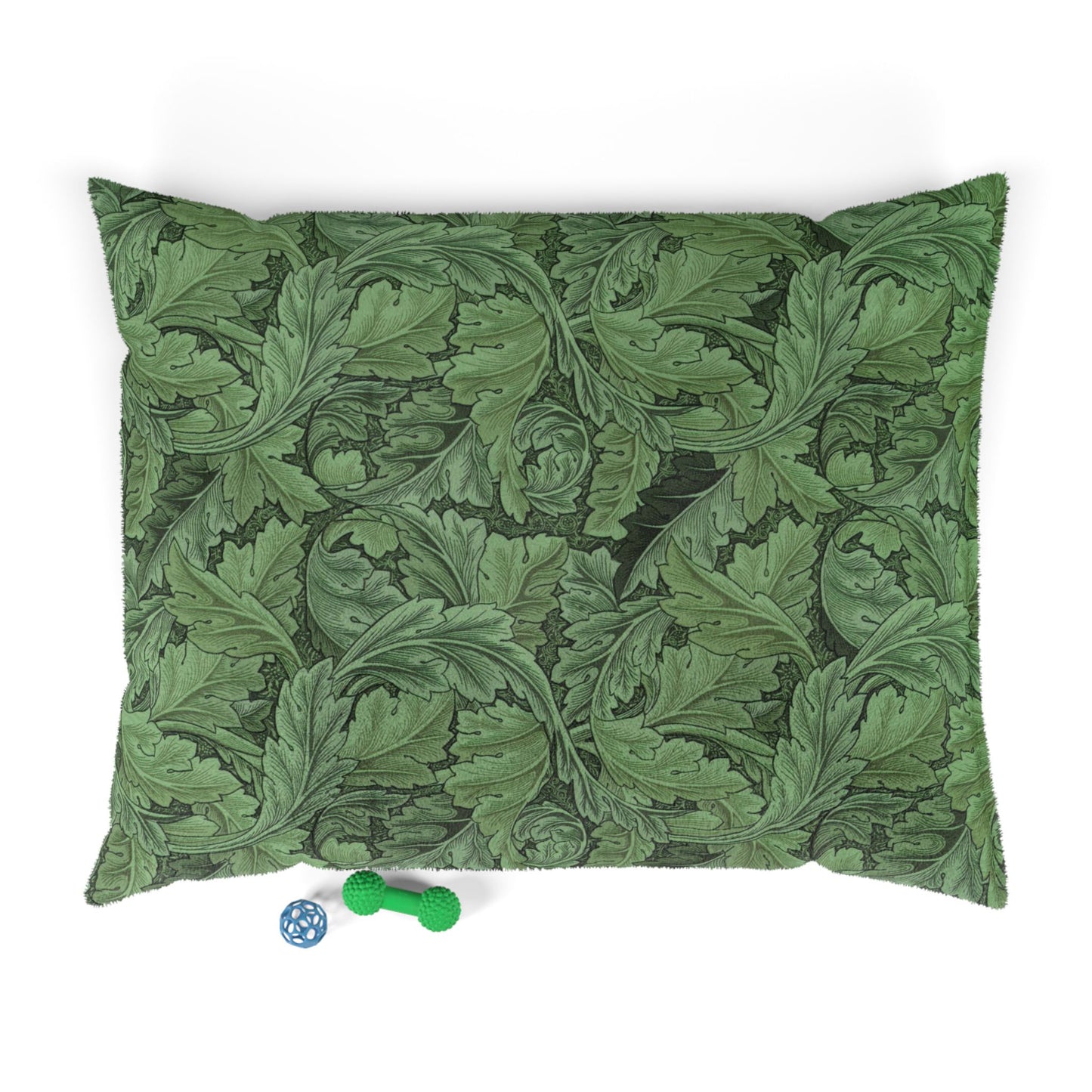 Green leaf-patterned pillow with two small toys on a white background