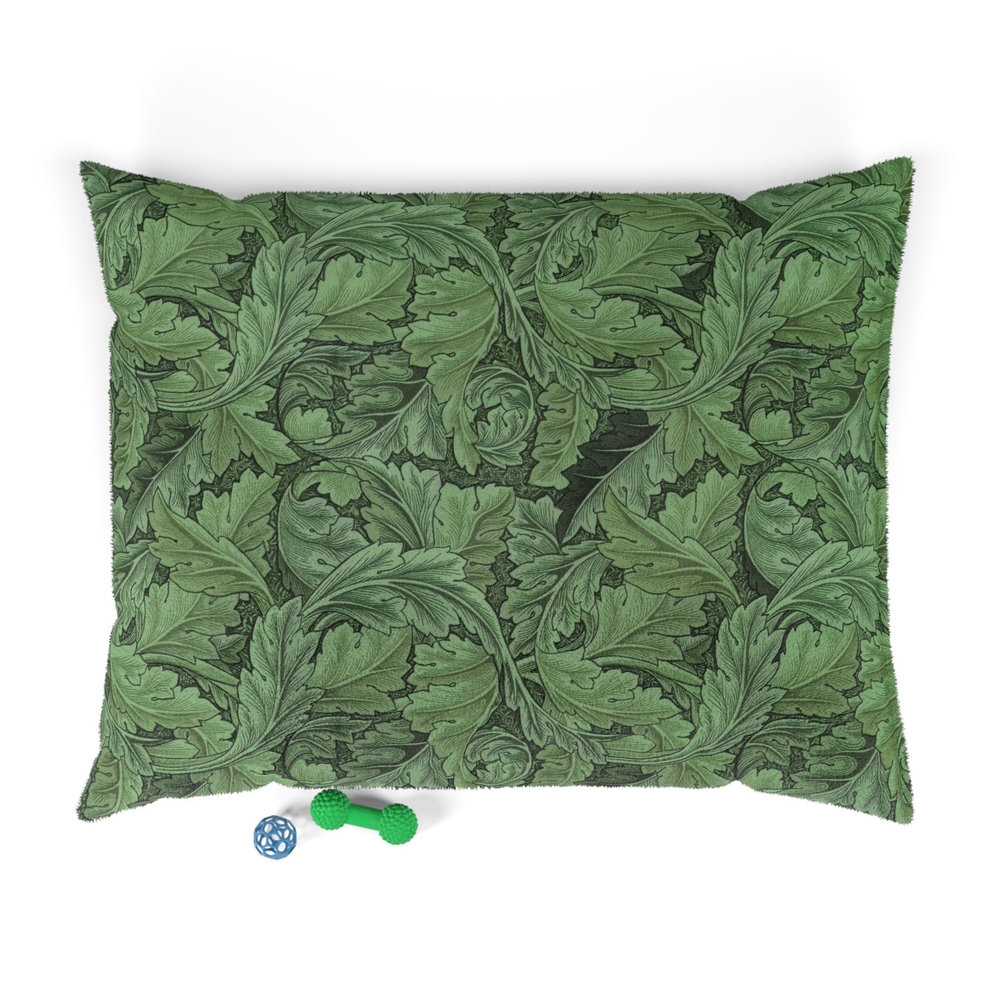 Green leaf-patterned pillow with two small toys on a white background