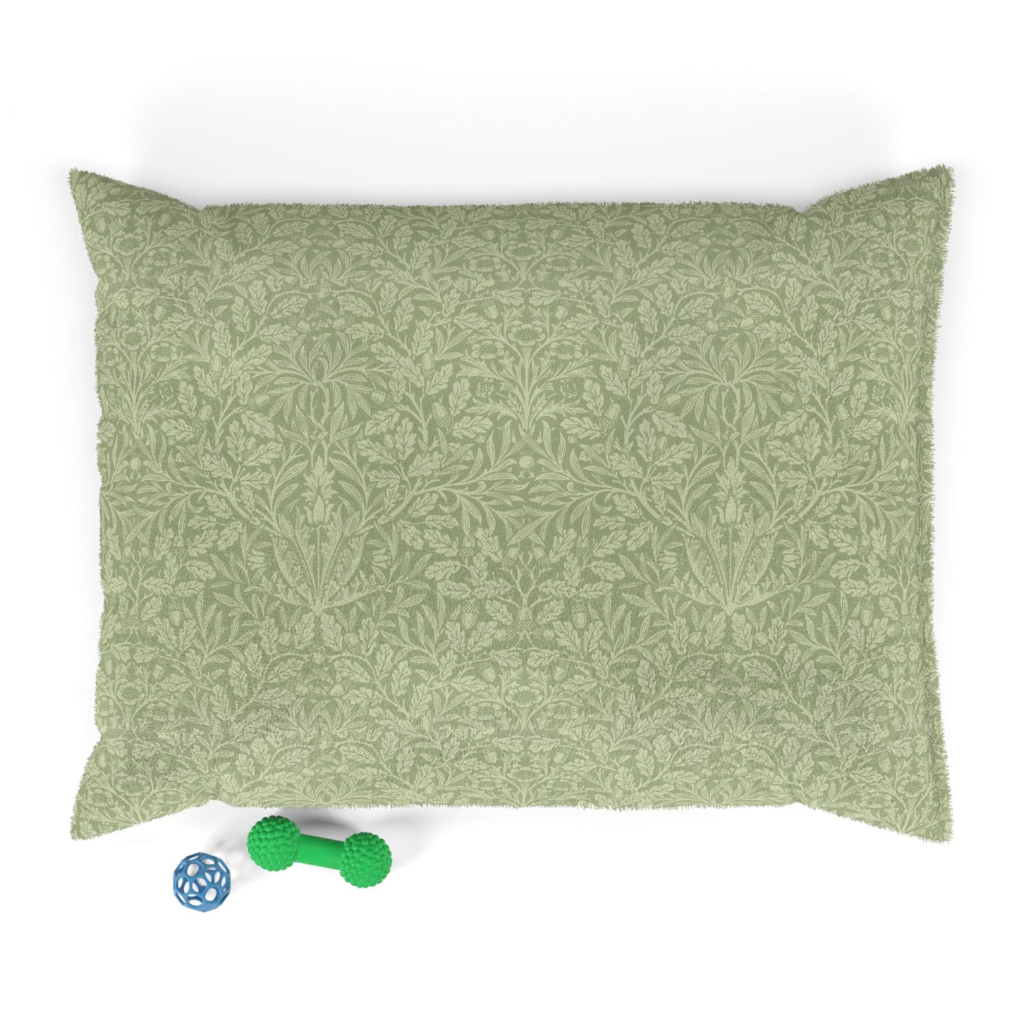 Green patterned pillow on a white background with a green dog toy below.