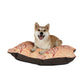 Dog sitting on a patterned dog bed with a white background