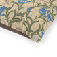 Floral patterned dog bed with blue flowers and green leaves on a beige background