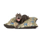 Dog lying on a William Morris & Co floral-patterned pet bed with a white background
