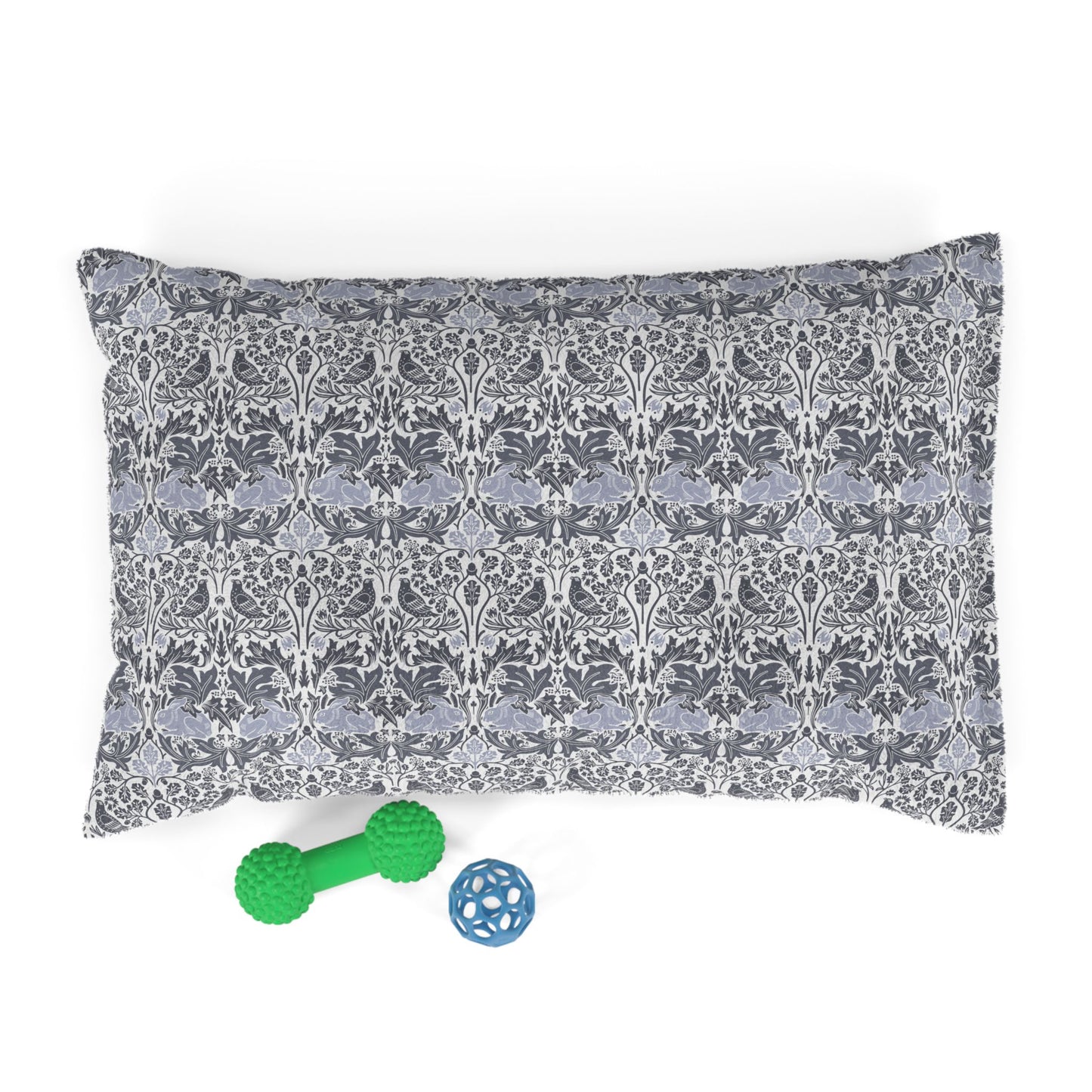 Patterned pet bed with two toys on a white background