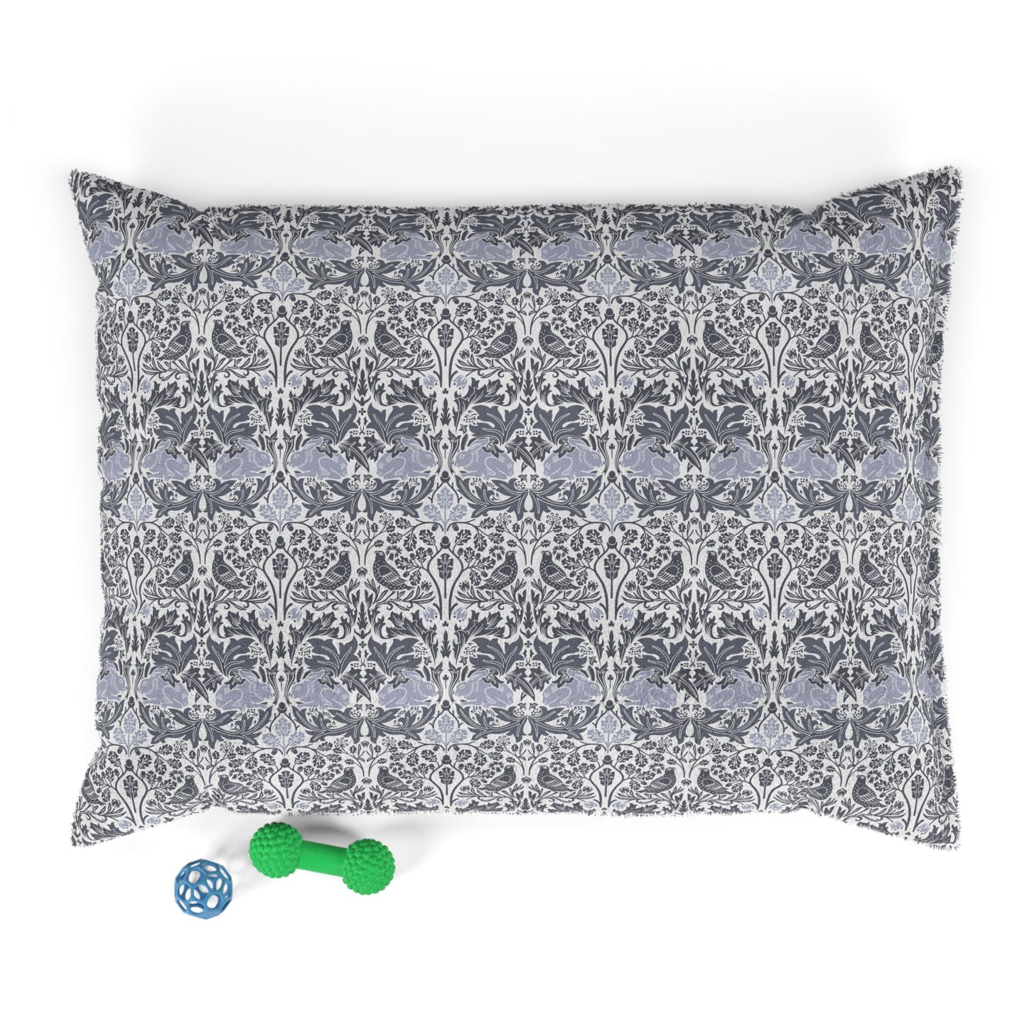 Patterned dog bed pillow with a small green and blue toy on a white background