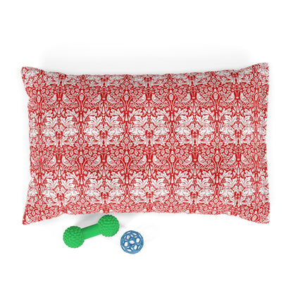 Red and white patterned pillow with two dog toys on a white background
