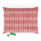 Red and white patterned pillow with two dog toys on a white background