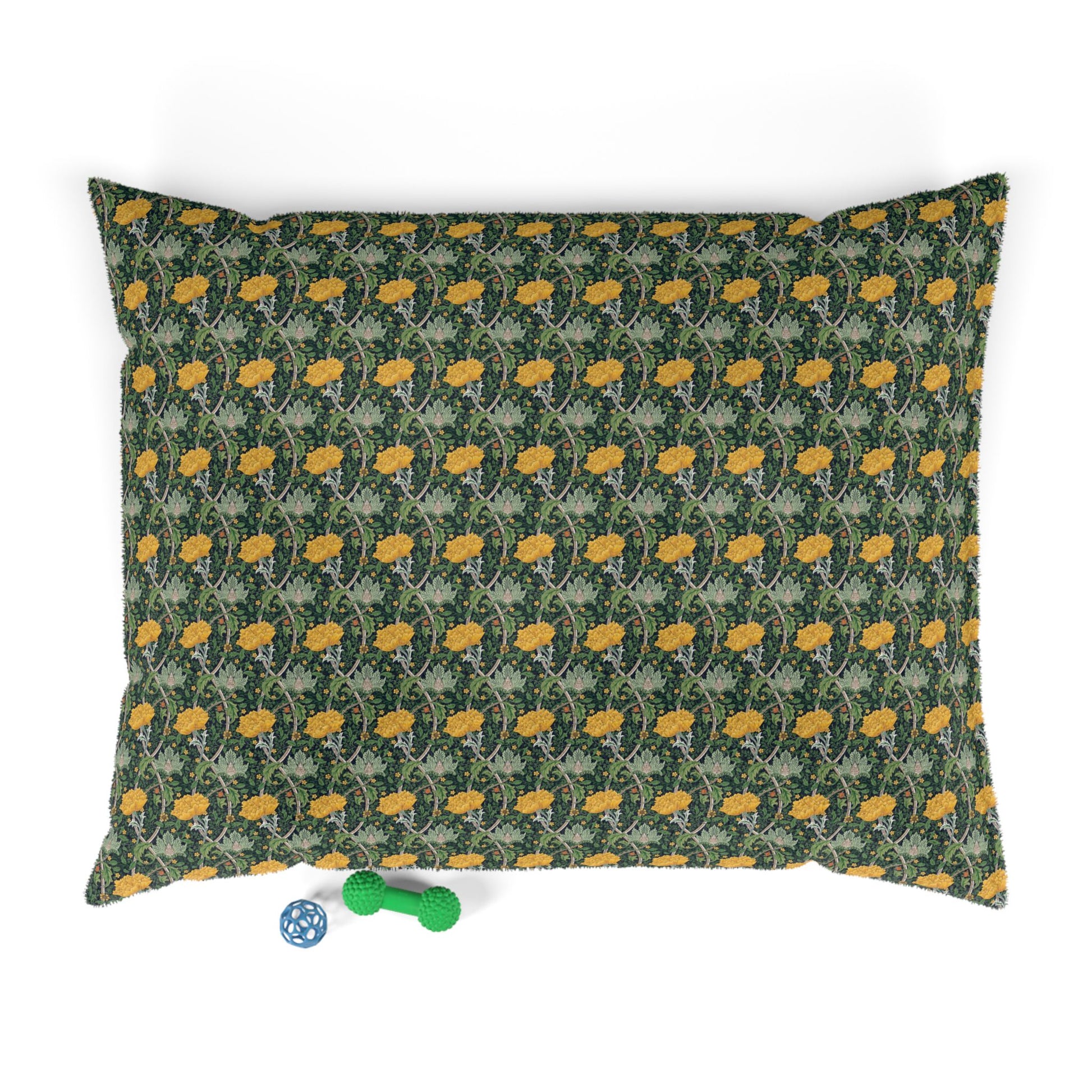 Patterned pillow with yellow flowers on a green background, with a small toy at the bottom.