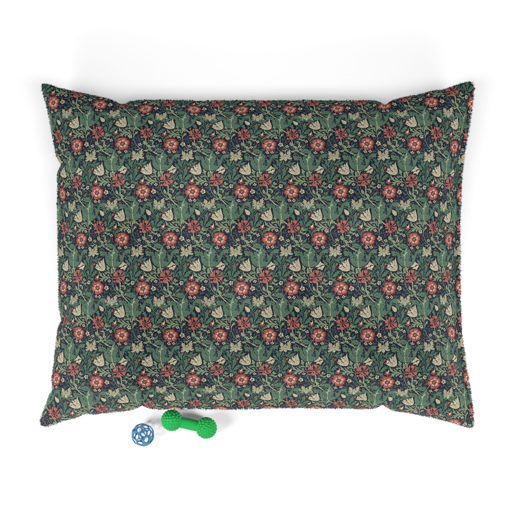 Floral patterned pet bed with two dog toys on a white background