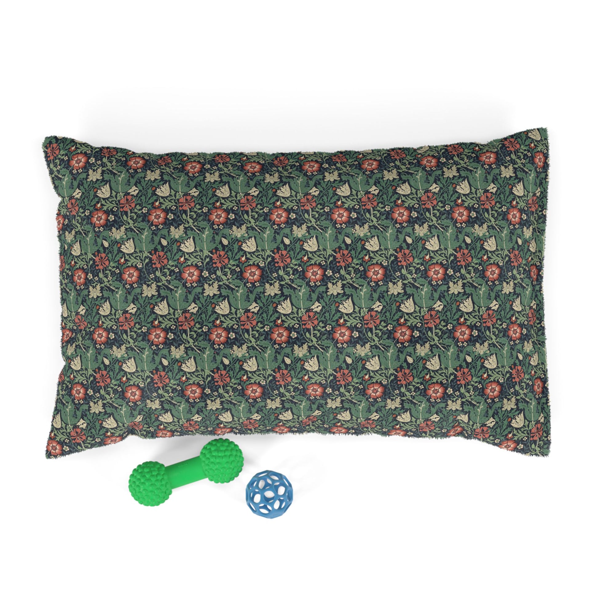 Floral-patterned pillow with two dog toys on a white background