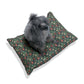 Dog sitting on a floral-patterned cushion with a white background