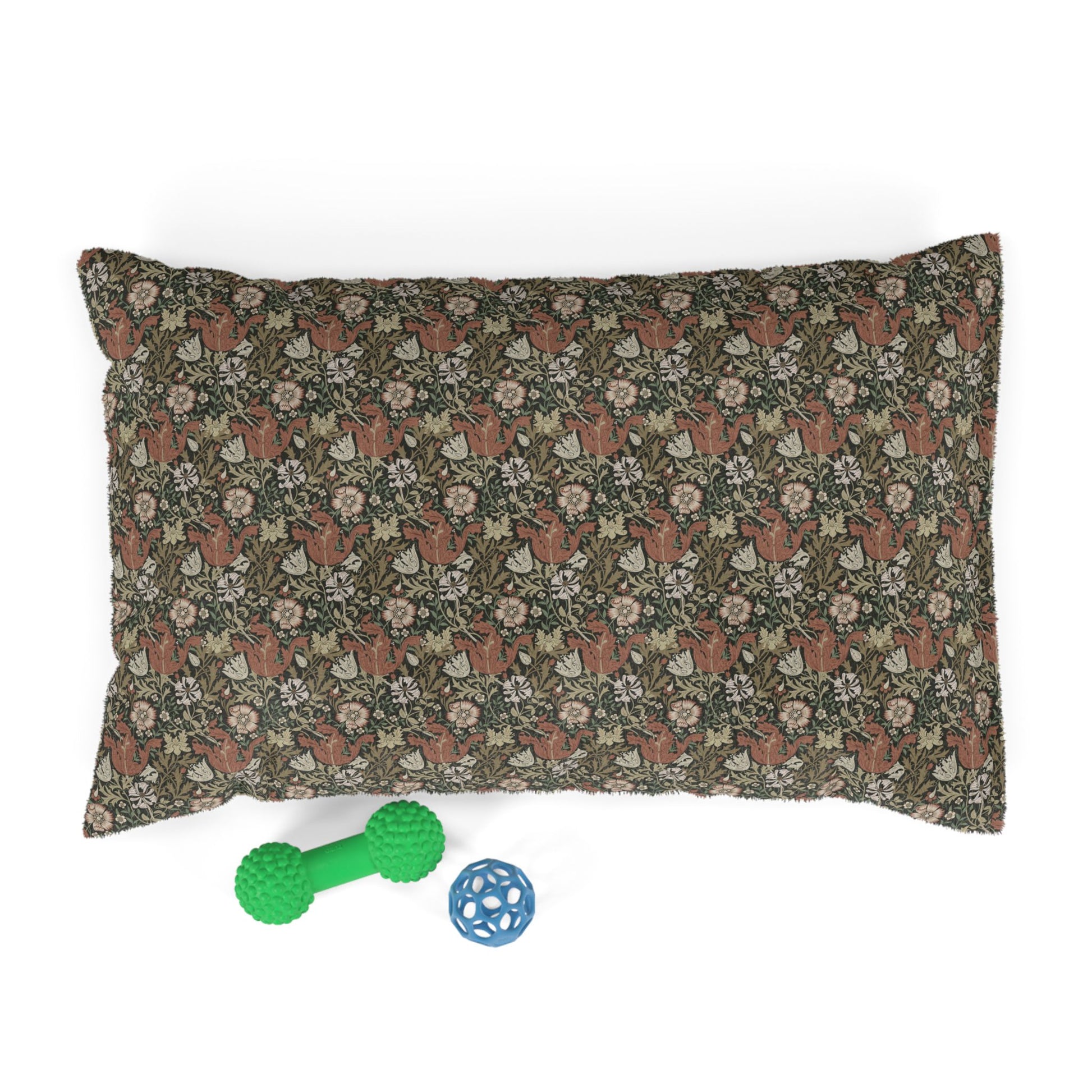 Floral-patterned pillow with two dog toys on a white background