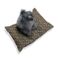 Dog sitting on a floral-patterned cushion with a white background