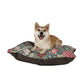 Dog sitting on a William Morris & Co floral-patterned dog bed with a white background