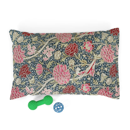 Floral William Morris & Co patterned pillow with two dog toys on a white background