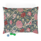 Floral William Morris & Co patterned pillow with a small green and blue toy on a white background