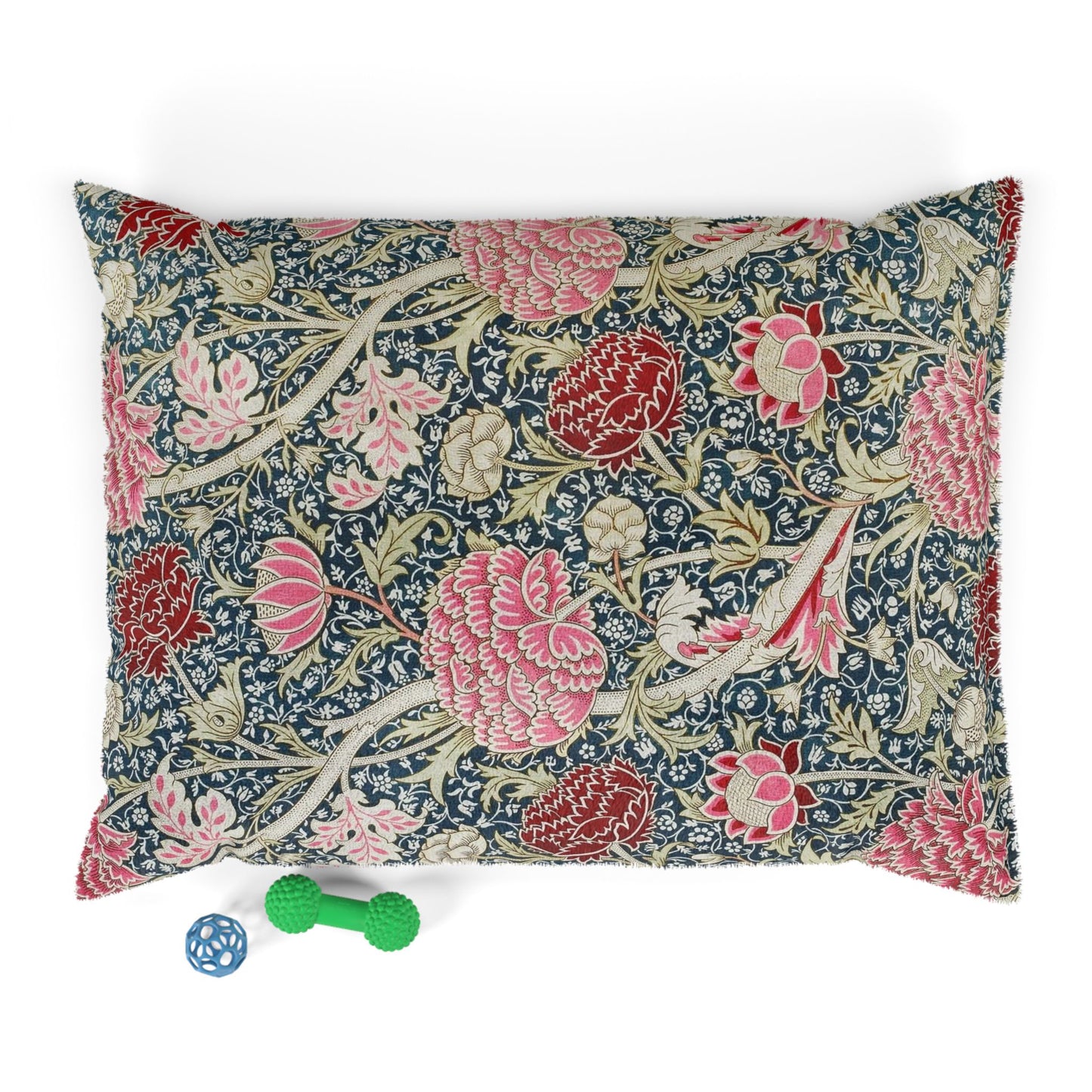 Floral William Morris & Co patterned pillow with a small green and blue toy on a white background