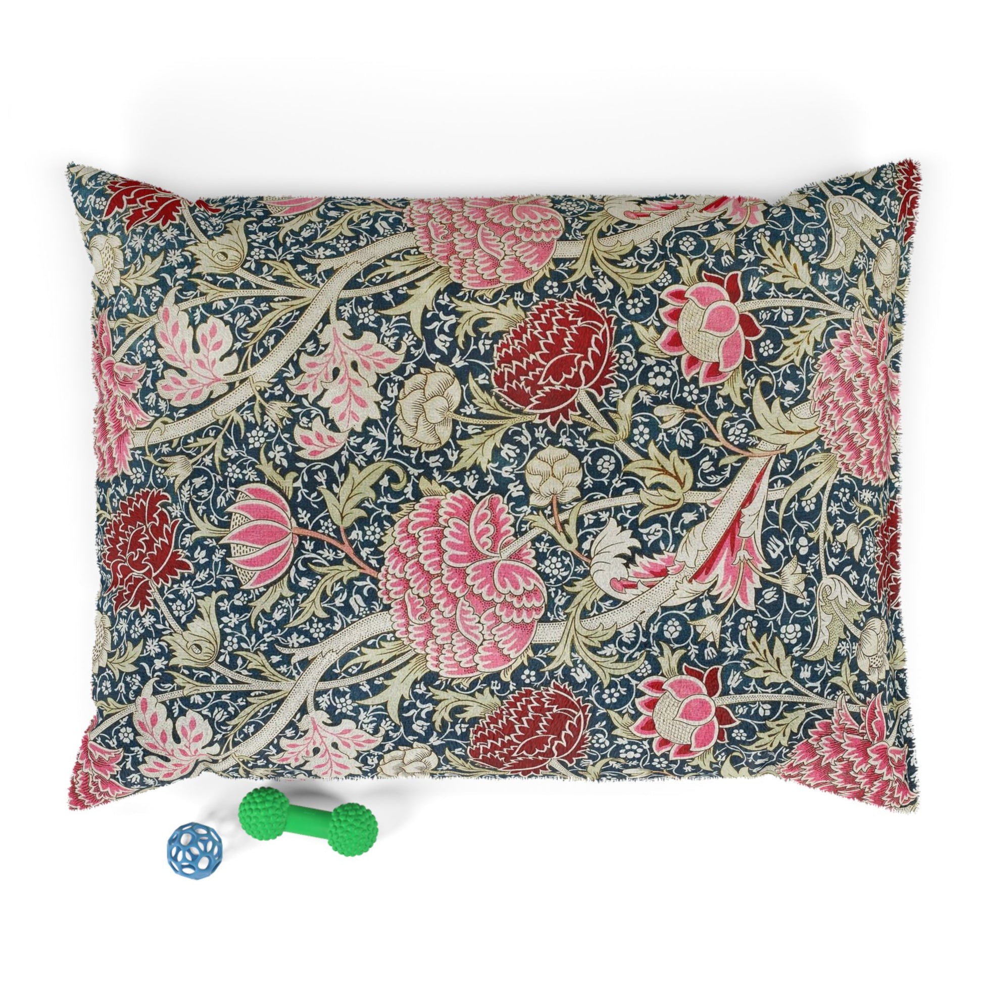 Floral William Morris & Co patterned pillow with a small green and blue toy on a white background