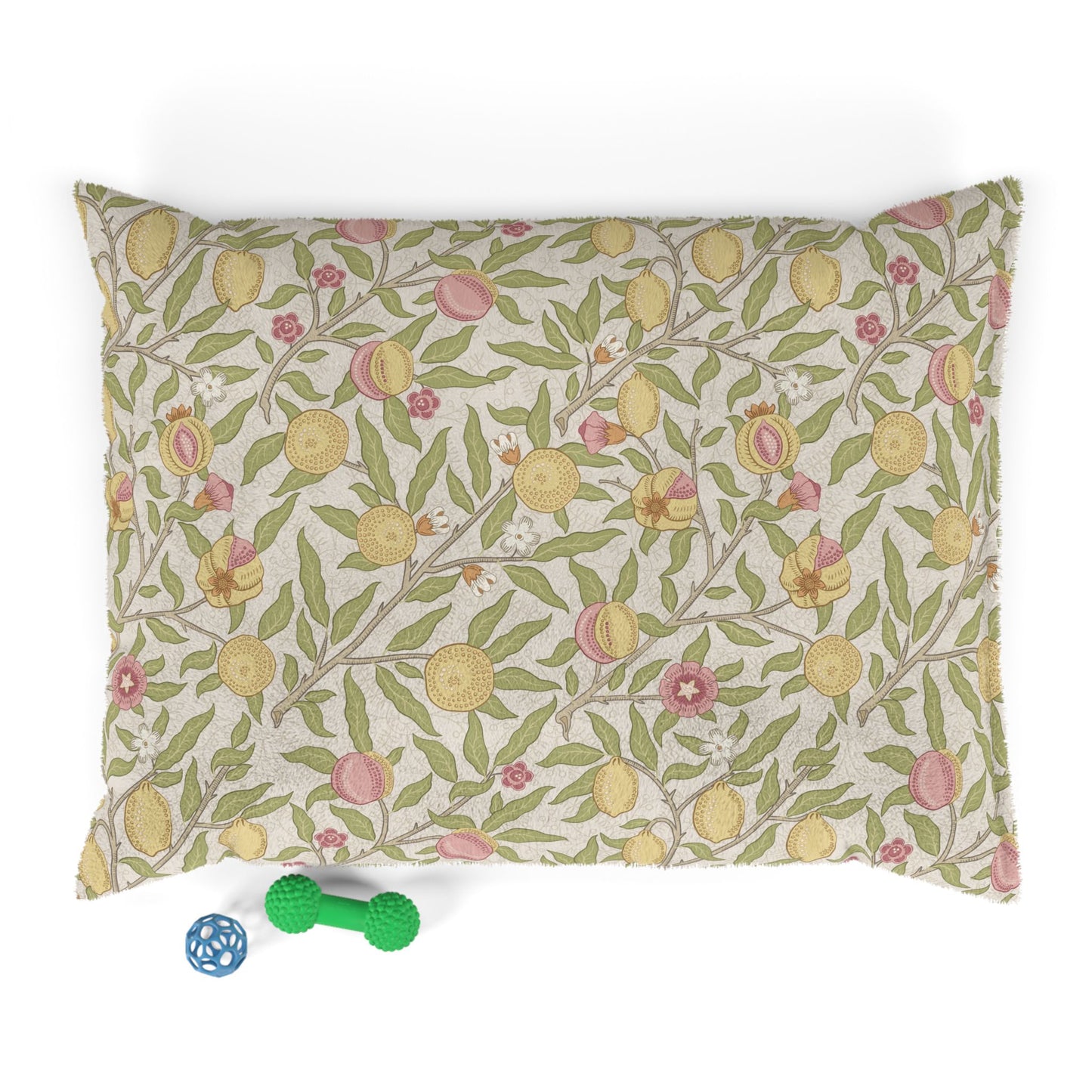Floral patterned dog bed pillow with dog toys on a white background