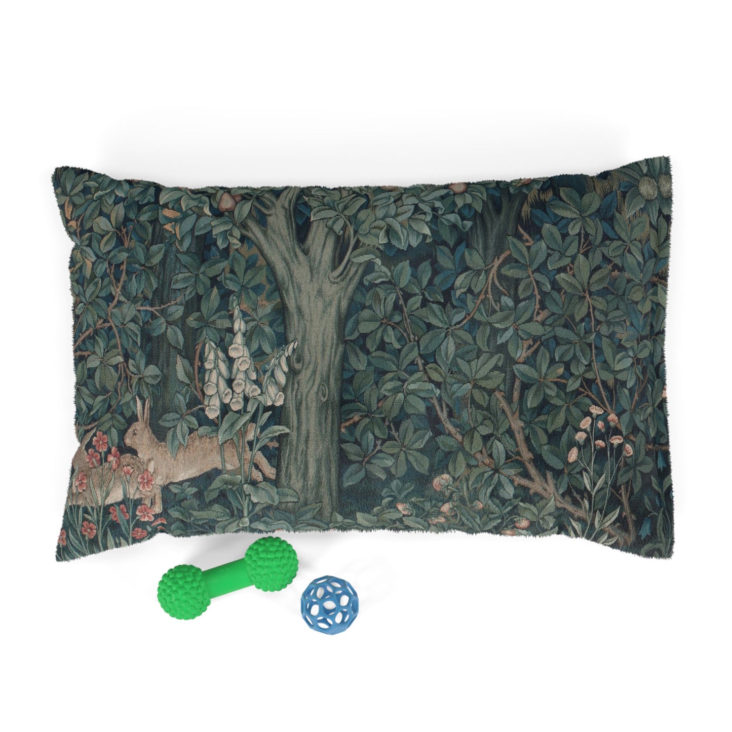 Decorative pillow with nature-themed design and two pet toys on a white background