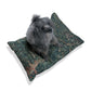 Dog sitting on a decorative pillow with a floral pattern on a white background