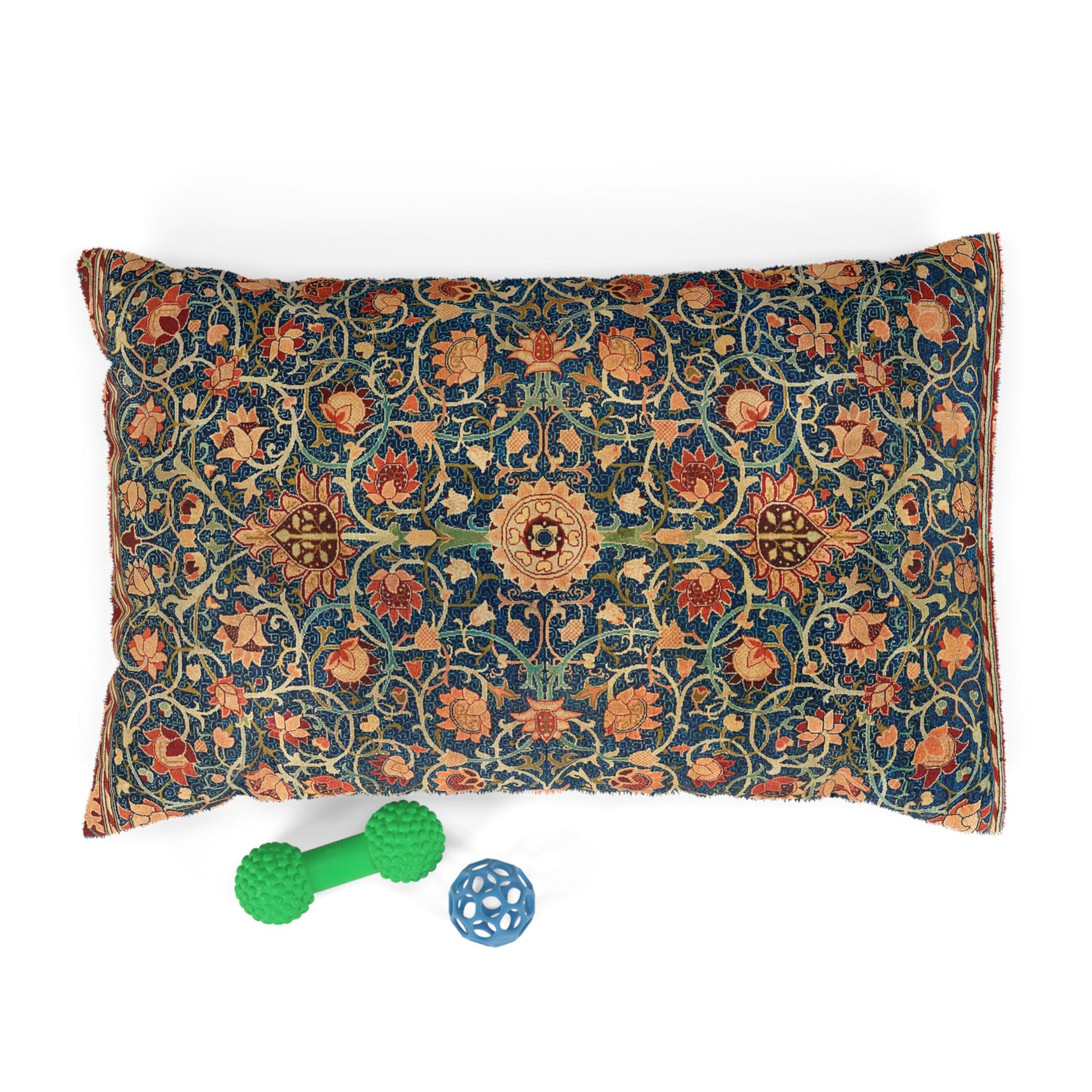 Decorative pillow with floral pattern and two pet toys on a white background