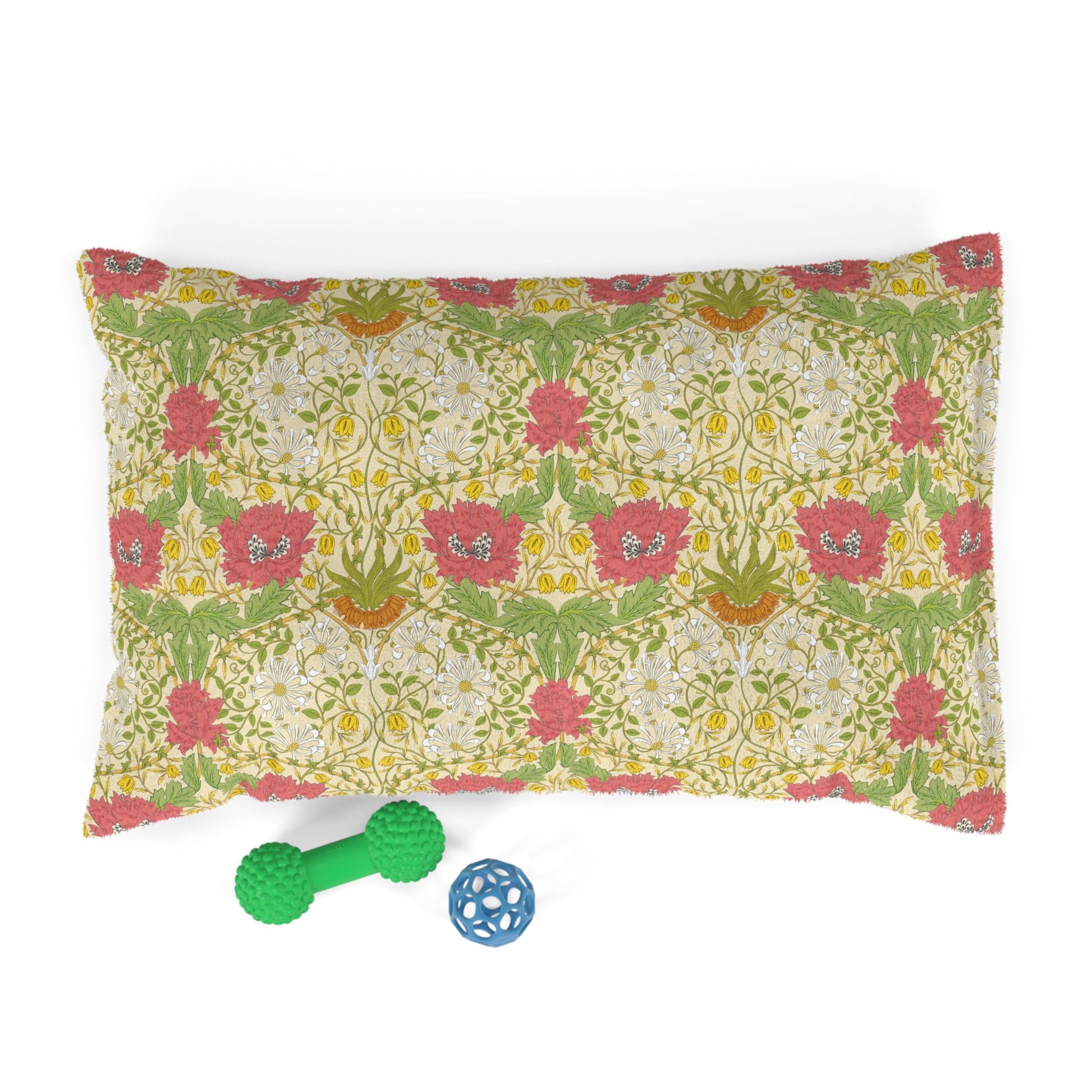 Floral-patterned pillow with two dog toys on a white background