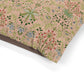 Floral patterned fabric with green, red, and blue colors on a pink background