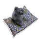 Dog sitting on a William Morris & Co floral-patterned dog bed with a white background