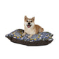 Dog sitting on a floral-patterned pet bed with a white background