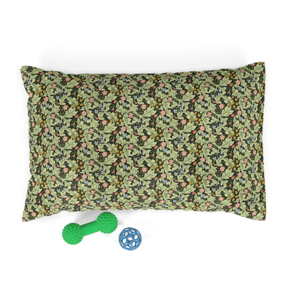 Floral-patterned pillow with a green dog toy and blue ball on a white background