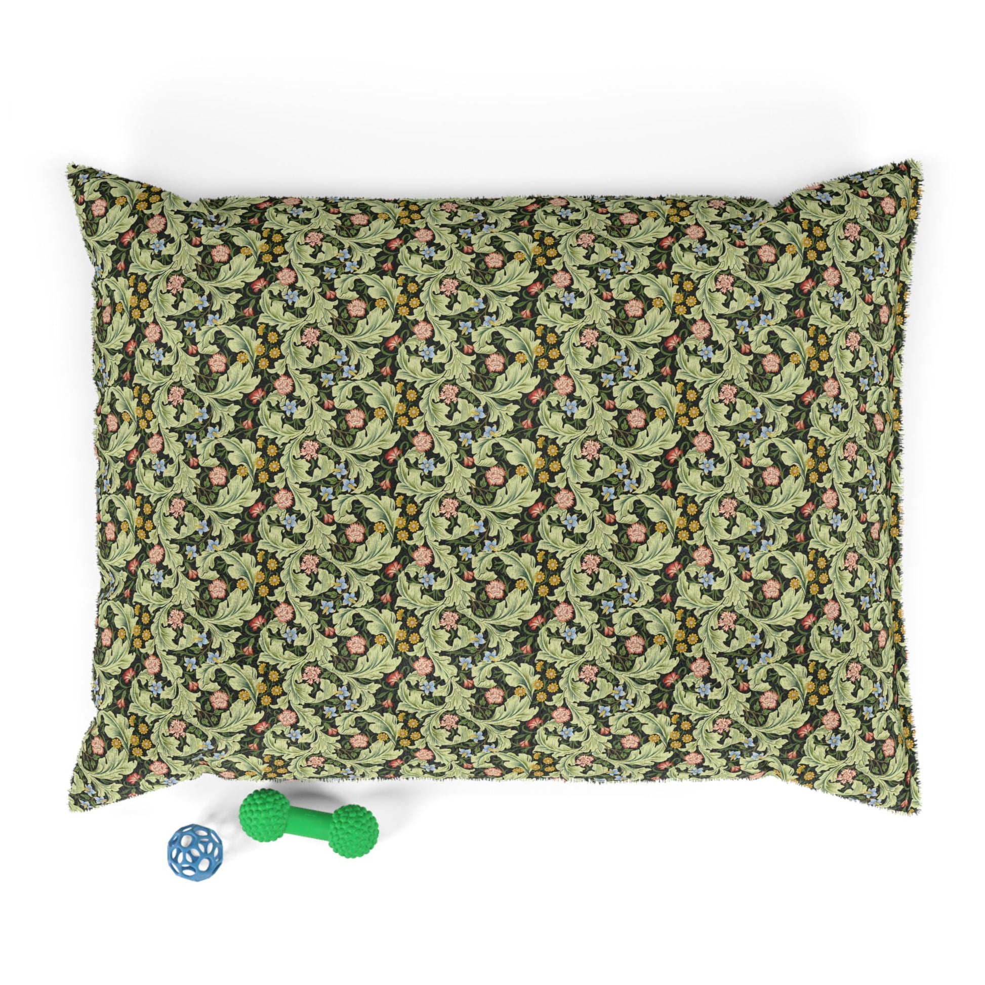 Floral patterned pillowcase on a white background with a green dog toy below.