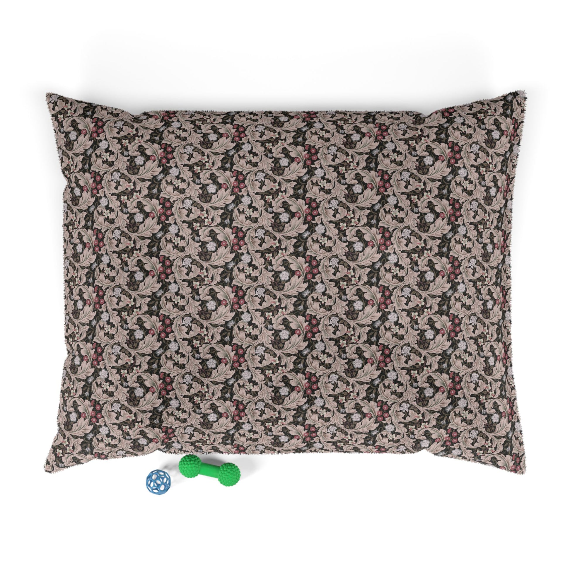 Floral-patterned pet bed with two dog toys on a white background