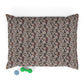 Patterned pillow on a white background with a green and blue toy at the bottom.