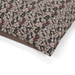 Close-up of a patterned fabric with pink and brown design on a white background