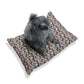 Dog sitting on a floral-patterned cushion with a white background