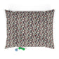 Floral patterned pet bed with two dog toys on a white background