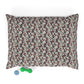 Floral patterned pet bed with small green and blue toys on a white background