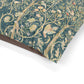 Close-up of William Morris & Co decorative dog bed with intricate patterns of birds and foliage on a teal background.