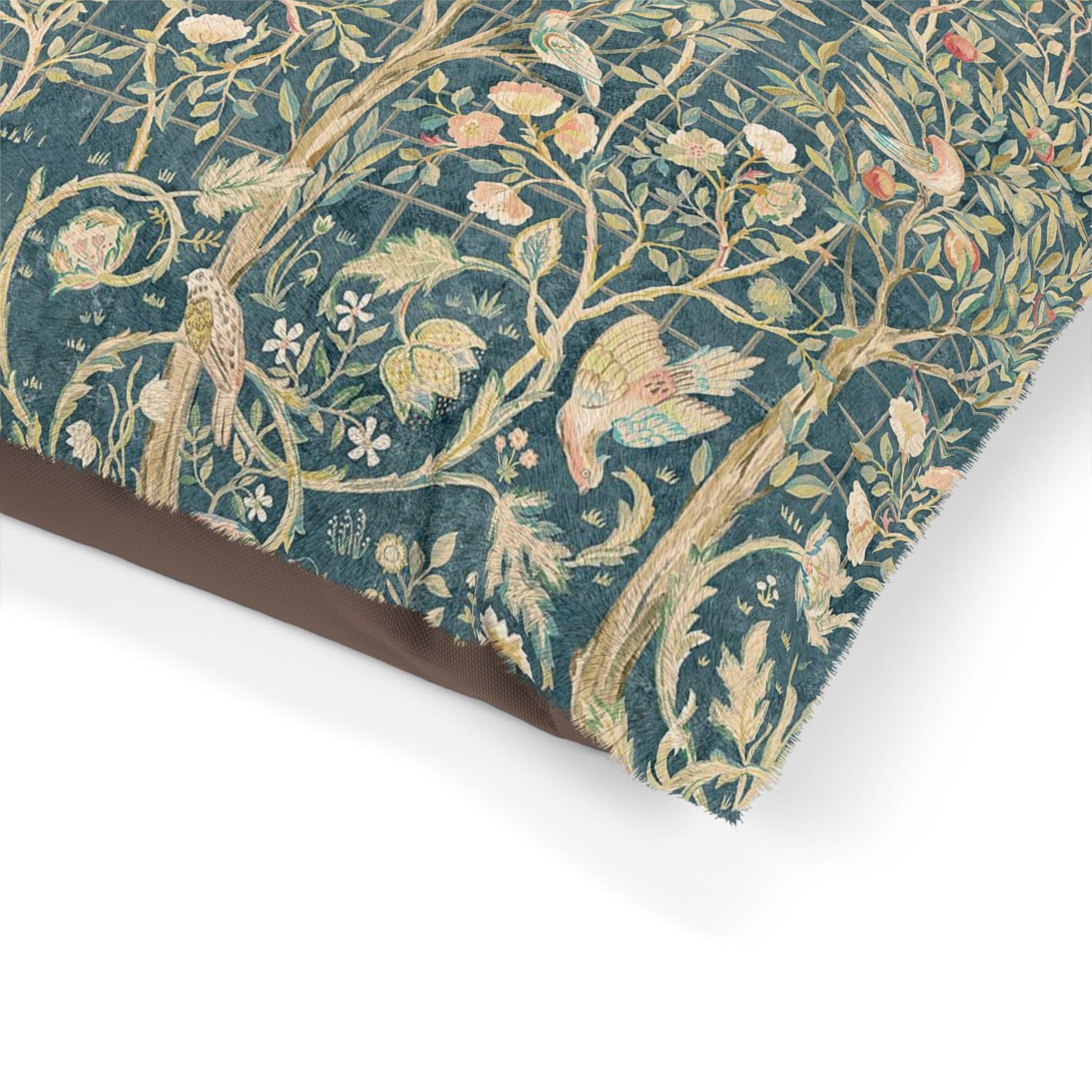 Close-up of William Morris & Co decorative dog bed with intricate patterns of birds and foliage on a teal background.