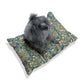 Dog sitting on a William Morris & Co floral-patterned cushion with a white background