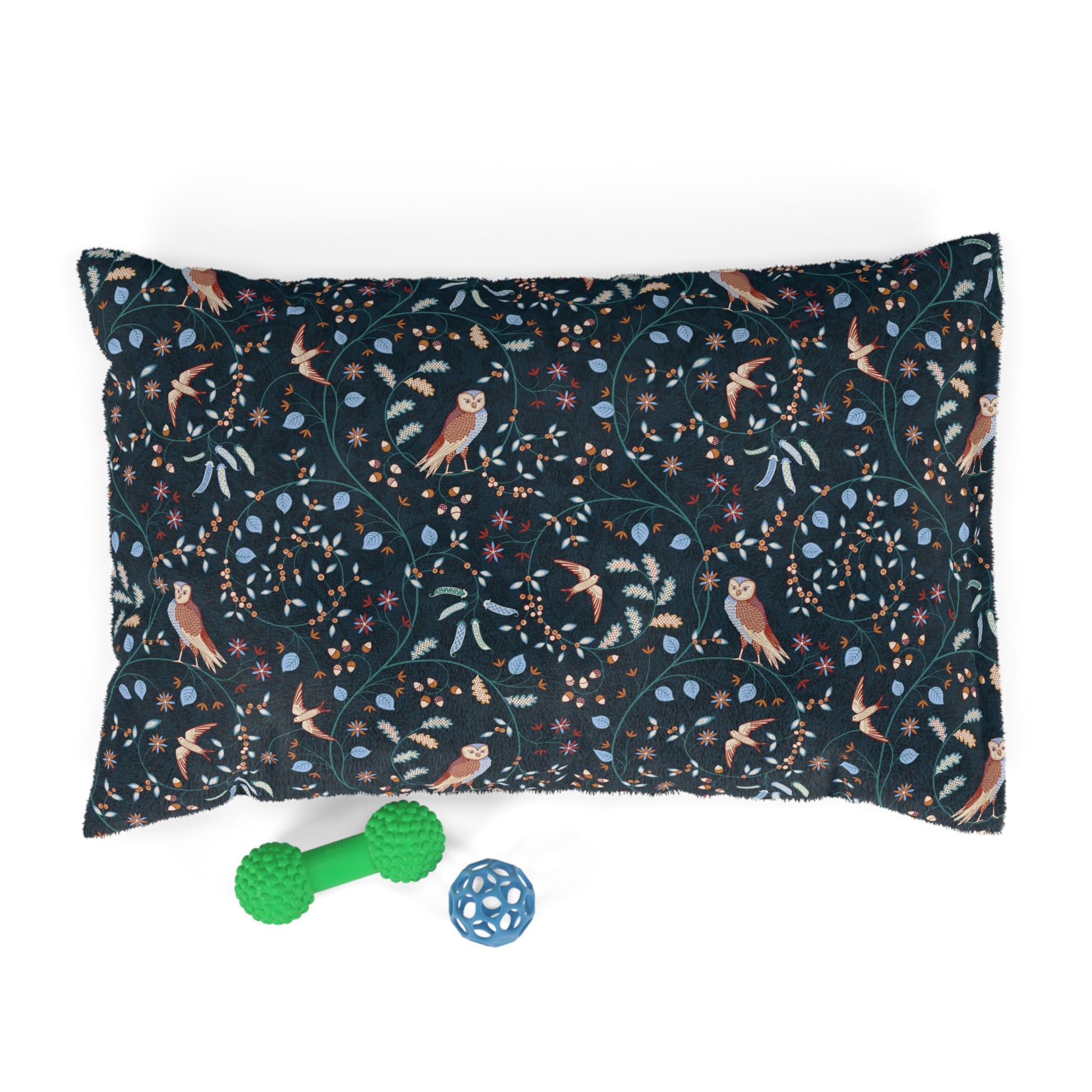 Decorative pillow with nature-themed pattern and two toys on a white background
