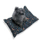 Dog sitting on a patterned pet bed with a white background